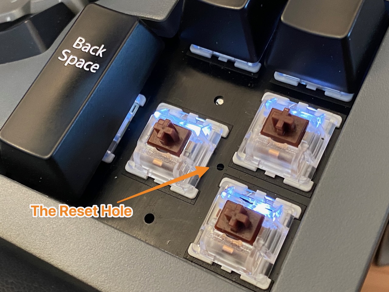 an annotated image of keys removed with an arrow pointing to the reset hole