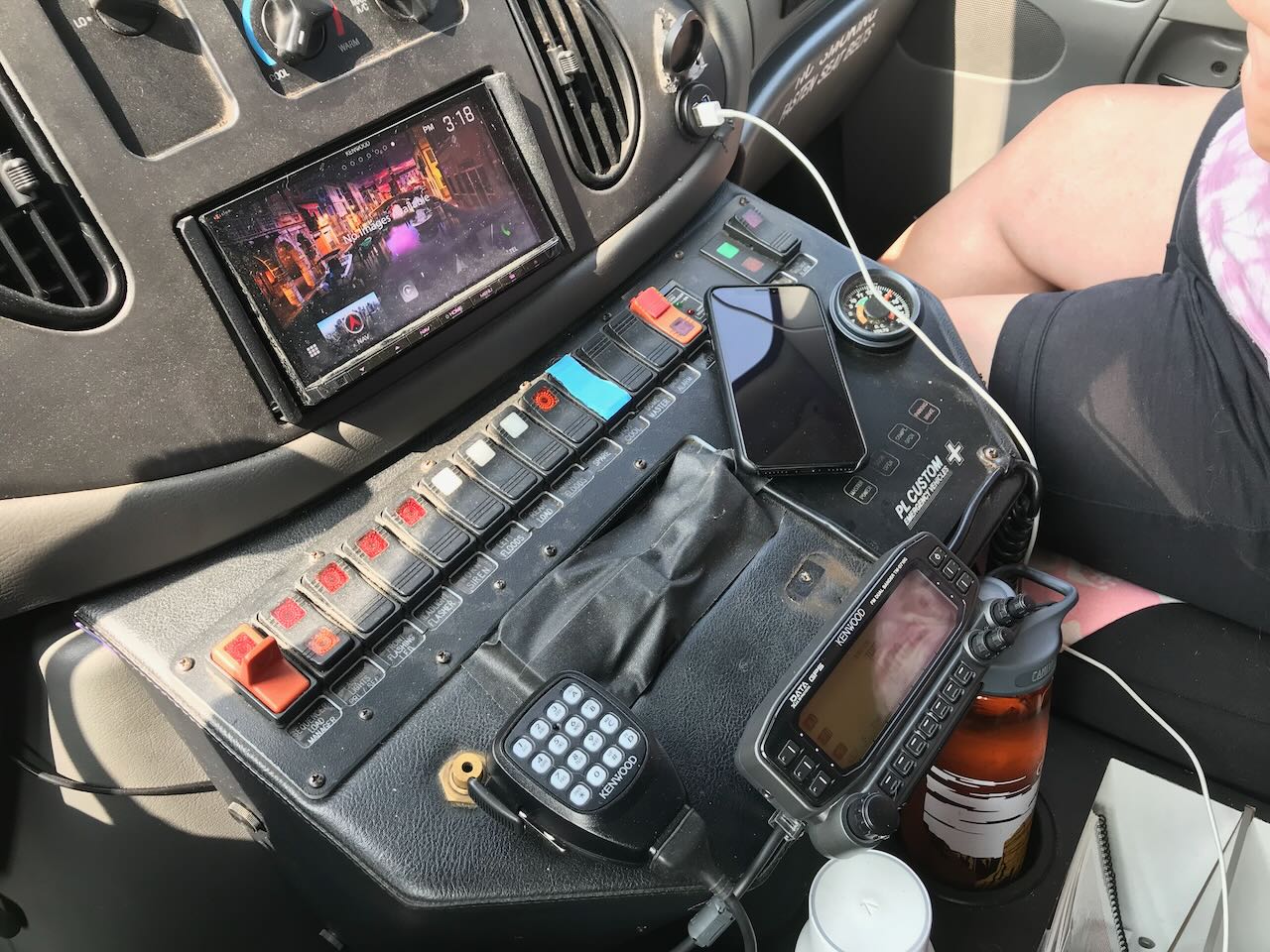 a picture of our ambulance dashboard. There are 14 toggle switches, a radial-dial voltmeter, indicator lights, a ham radio, and a ham radio handset
