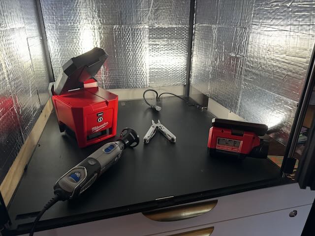 a photo of the inside of my enclosure containing two Milwaukee lights, a dremel, and a Leatherman.
