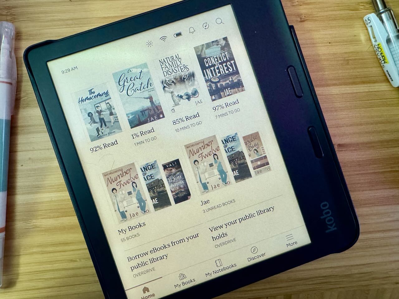 A photo of my current home screen. The Kobo is sitting on a bamboo desk. pens can be seen on the sides of the photo